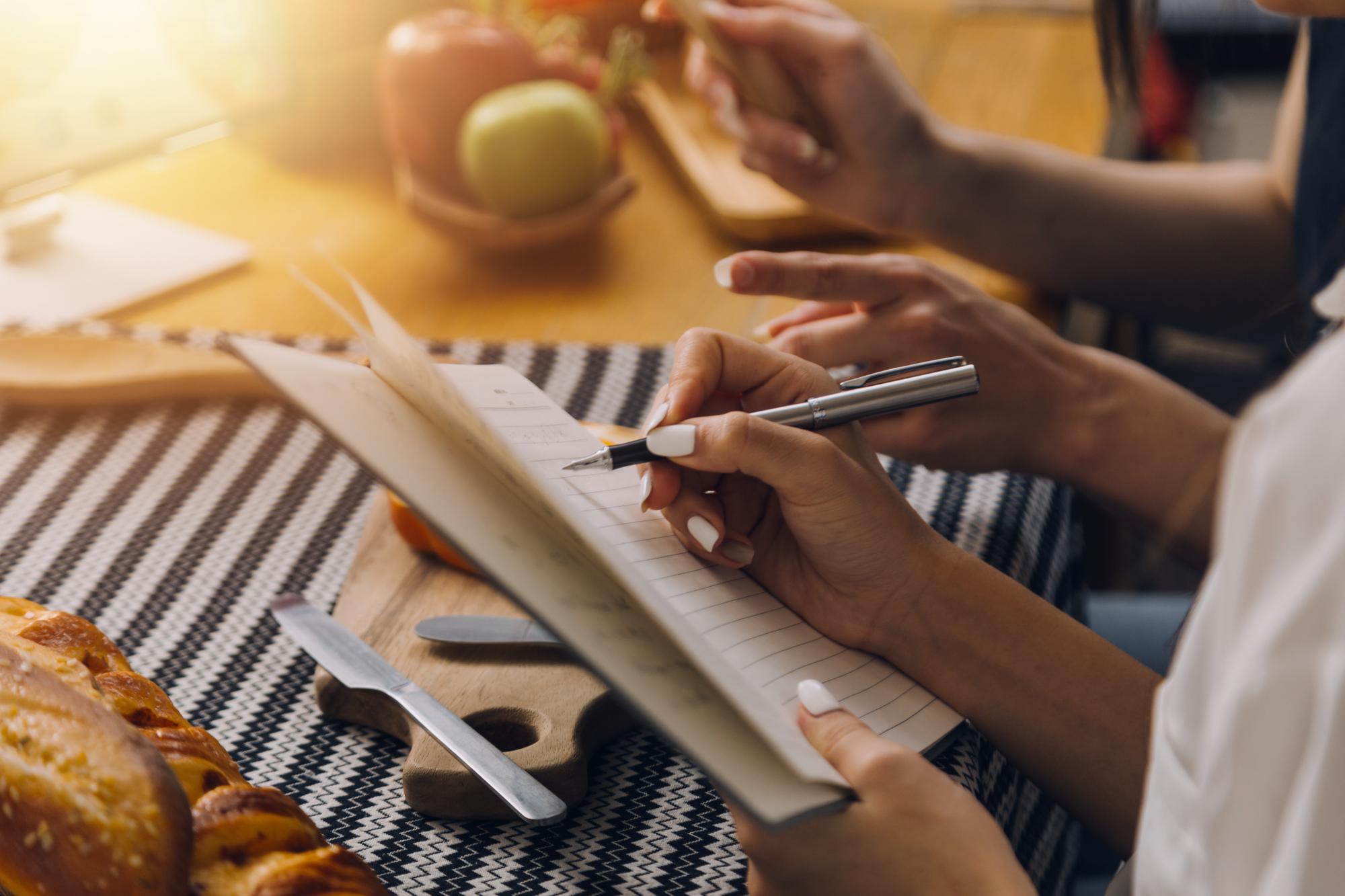 Pricing visual: hands writing menu on paper